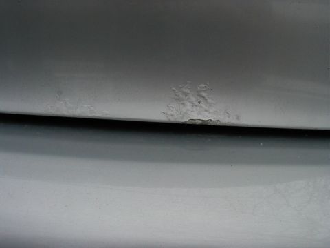 1997 Ford Taurus - Corrosion is visible on the edge of a vehicle's body panel.