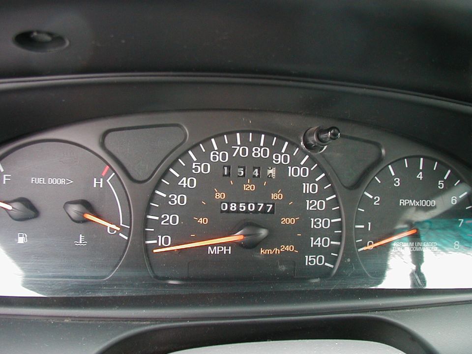 Car dashboard with speedometer, tachometer, fuel, and temperature gauges. Odometer shows 85,077 miles