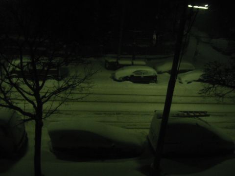 1992 Ford Crown Victoria - A nighttime scene shows multiple vehicles blanketed in snow, with a streetlamp illuminating the wintry conditions.