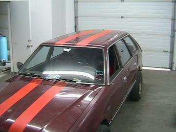 1981 Chevrolet C/K Pickup - Station wagon with racing stripes in a garage. The model year is not identifiable.