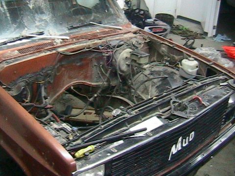 1981 Chevrolet C/K Pickup - The engine bay of a 1981 Chevrolet C/K Pickup is shown with the engine removed, revealing the firewall and surrounding components.