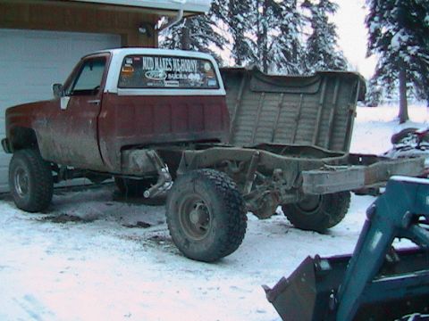 1981 Chevrolet C/K Pickup - This pickup truck chassis, likely from the 1970s, is missing its bed and sits in a snowy environment.