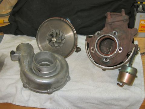 1985 Ford LTD Crown Victoria - A disassembled turbocharger laid out on a white towel, showing the polished aluminum compressor housing, the exposed bladed compressor whee…