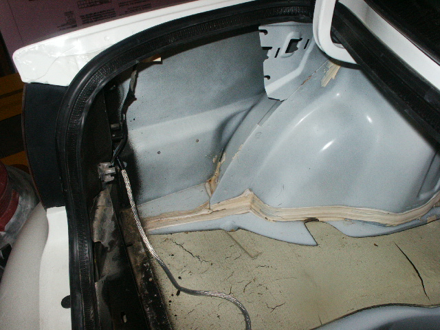Interior of a car trunk showing sound dampening material and wiring