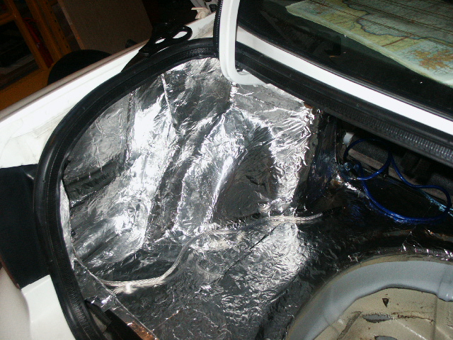White car trunk lined with silver foil sound-deadening material