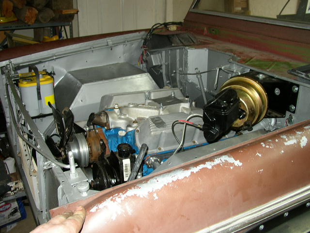 Engine bay of a Ford Bronco, showing the engine, brake booster, and battery
