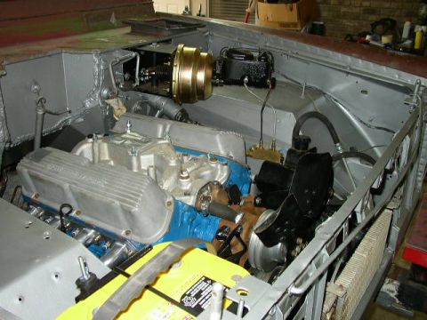 1995 Ford Bronco - The engine bay of a vehicle, a V8 engine, brake booster, and radiator, appears to be undergoing restoration or modification.