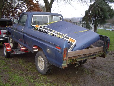 1979 Ford Bronco - A blue Ford pickup truck, likely from the late 1970s, is loaded onto a U-Haul trailer.