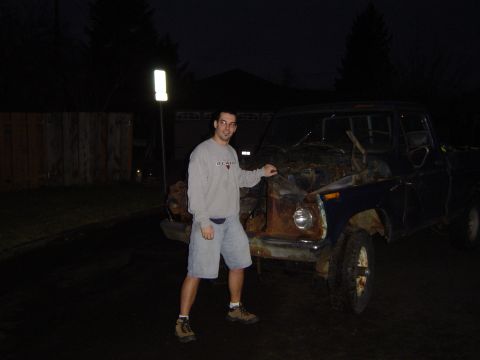 1979 Ford Bronco - A man stands next to a heavily rusted truck, its hood open, revealing the engine bay.