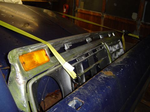 1979 Ford Bronco - A close-up view of a vintage Ford truck grille, secured with yellow straps.