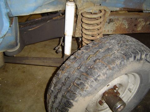 1979 Ford Bronco - Detail shot of a vehicle's suspension system, showing a tire and rusty components.