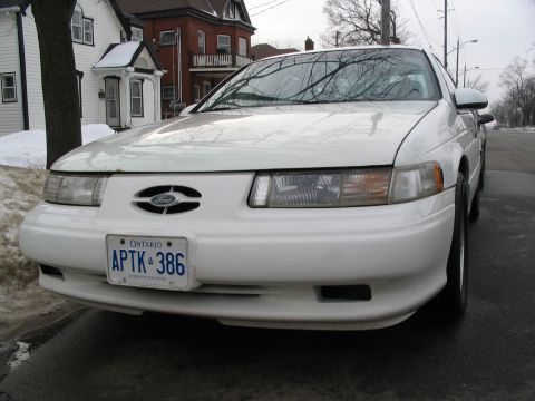 1993 Ford Taurus - Front view of a white 1993 Ford Taurus parked on a street in winter.