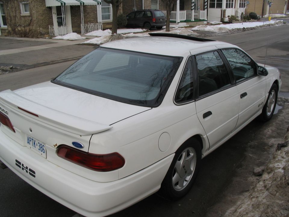 White 1993 Ford Taurus SHO parked on a snowy street