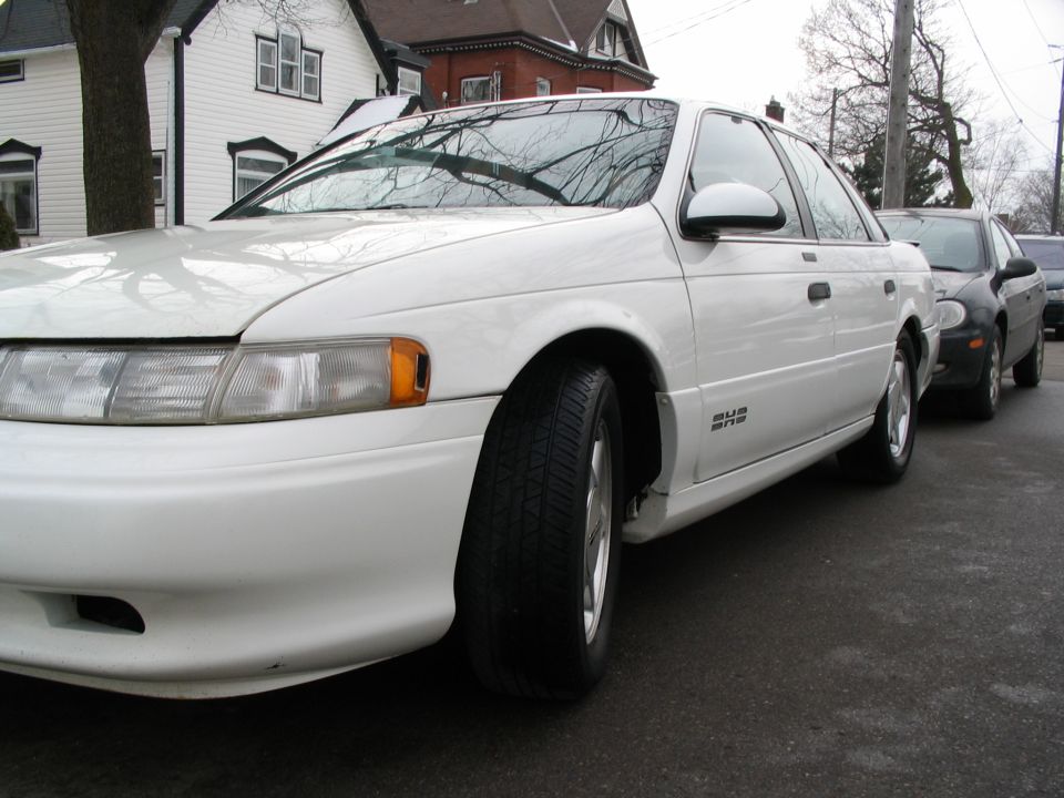 1993 Ford Taurus sedan parked on street, another car behind it