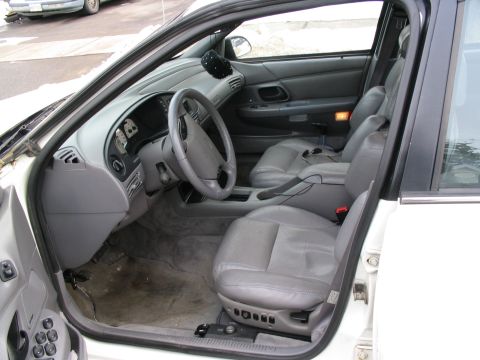 1993 Ford Taurus - The interior of a 1995 Ford Taurus, viewed from the driver's side door, reveals gray leather seats and dashboard details.