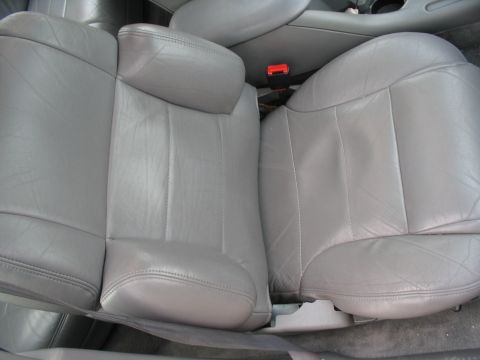 1993 Ford Taurus - Interior view of gray leather seats, showing stitching detail and a red seatbelt buckle.