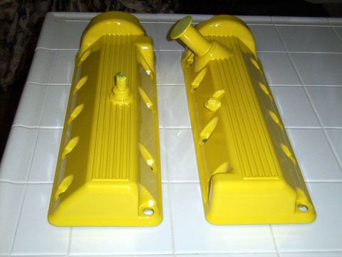 2002 Ford Mustang - Pair of yellow valve covers, likely for an engine, are displayed on a tiled surface.