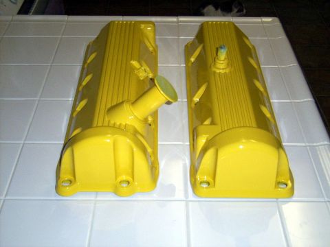 2002 Ford Mustang - Two yellow valve covers are displayed on a tiled surface, likely for an engine rebuild or custom modification.