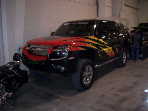 1999 Jeep TJ - Customized Chevrolet Avalanche truck with unique graphics and modifications, seen at a car show.