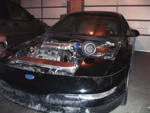 1994 Ford Probe - Front view of a black car with its engine exposed, revealing a turbocharger and Ford emblem.
