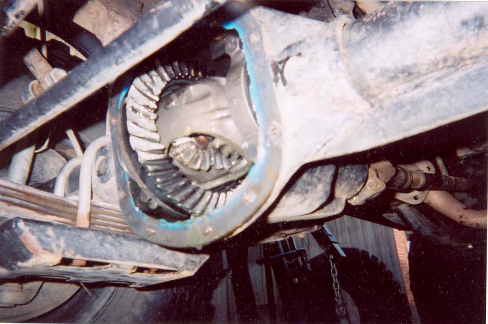 close-up of vehicle's rear differential and axle assembly, showing gears and leaf springs