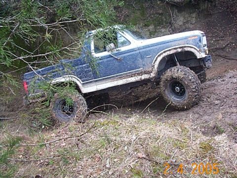 1986 Ford Bronco - This 1986 Ford Bronco navigates a challenging muddy terrain, its off-road capabilities.