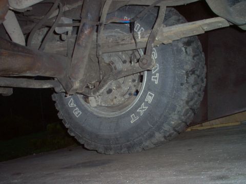 1979 Ford Bronco - Underside view of a vehicle's rear axle, suspension, and tire.