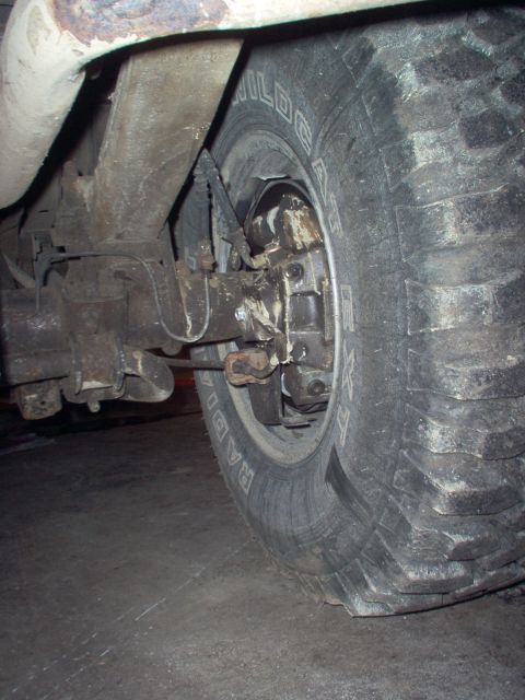 1979 Ford Bronco - Close-up view of the rear axle and tire assembly, showing brake components and suspension.