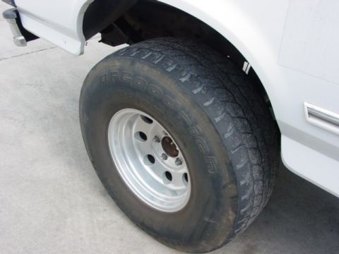 1996 Ford Bronco - A close-up shot focuses on the tire and wheel well of a vehicle, with visible tire branding.