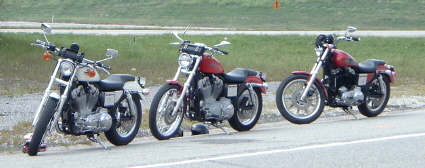 1995 Mercury Grand Marquis - Three Harley-Davidson motorcycles are parked in a row along the side of a road.