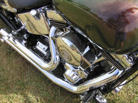 1995 Mercury Grand Marquis - The shiny chrome exhaust pipes and engine details of a motorcycle are visible in this close-up shot.
