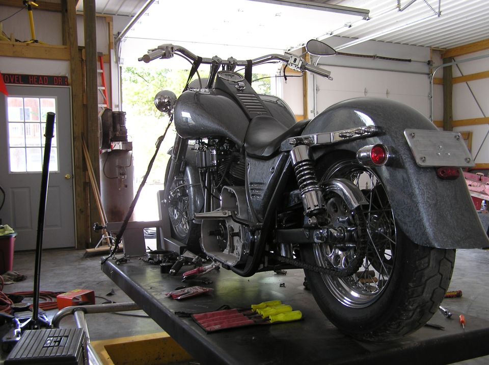 Motorcycle on a lift, grey speckled paint, chrome accents, in a garage