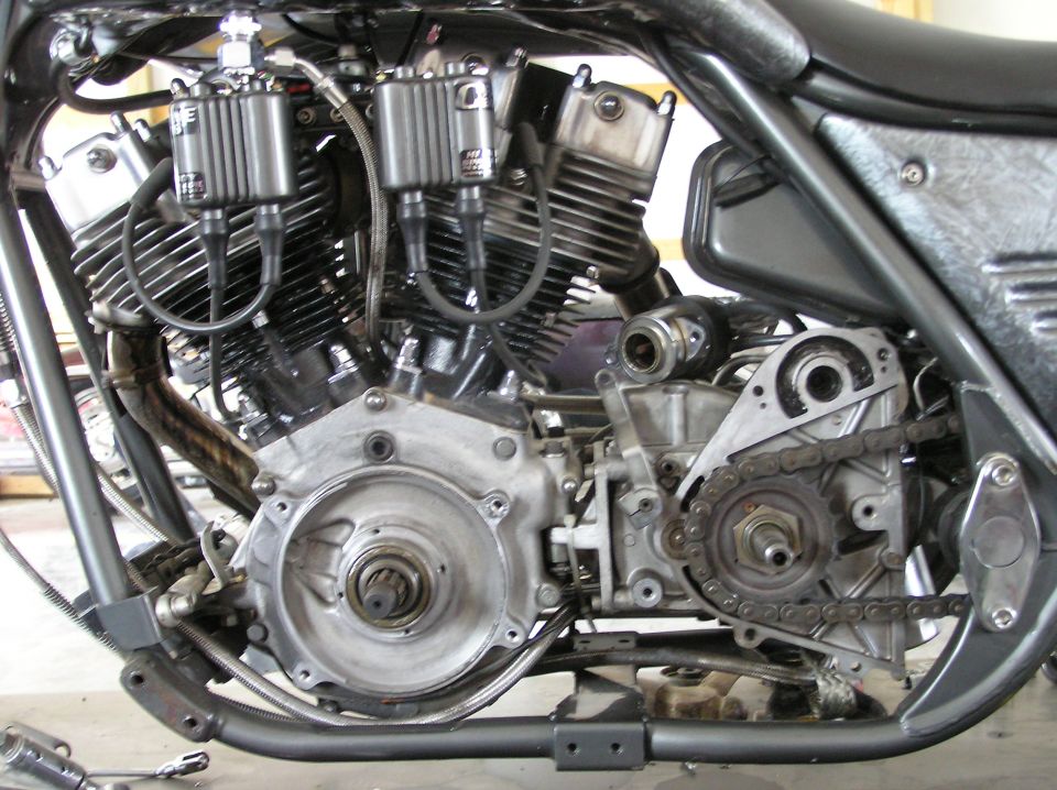Motorcycle engine with chrome accents, dual spark plug wires, and a visible drive chain