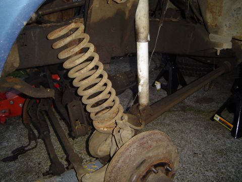 1979 Ford Bronco - Close-up view of a heavily rusted rear suspension system, likely from a 1970s era truck or SUV.