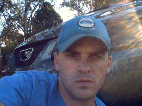 2003 Ford Mustang - A man poses for a selfie in front of a car, with the vehicle's grille and emblem clearly visible.