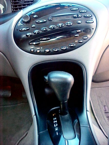 1997 Ford Expedition - The interior of a vehicle shows the center console with a gear shifter and numerous dashboard controls.