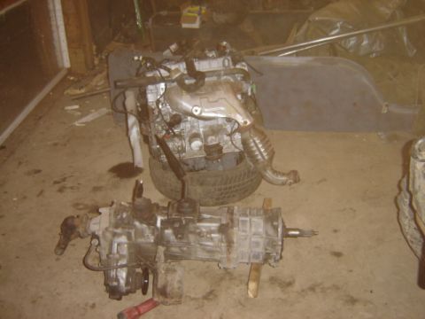 1992 Ford Bronco - Engine and transmission components are displayed on the floor, possibly for repair or replacement.