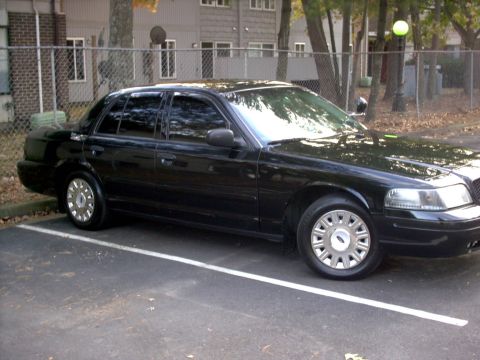 2001 Ford Crown Victoria - Side profile of a black 2001 Ford Crown Victoria parked in a lot.