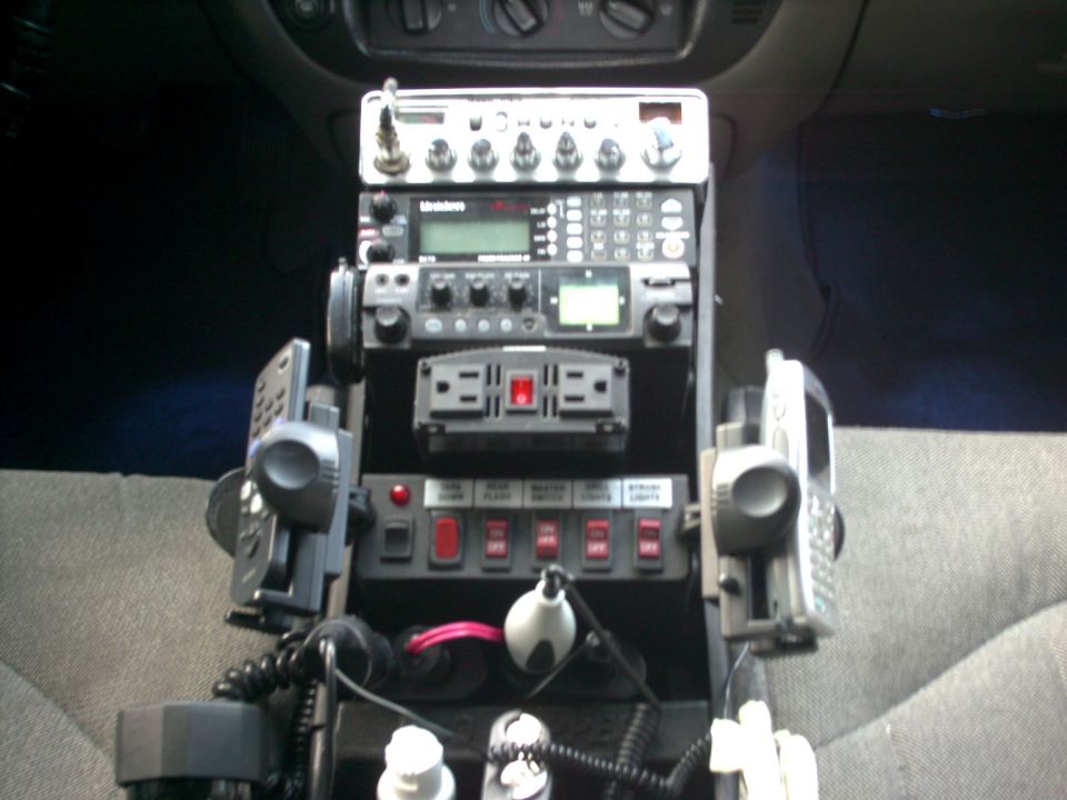 Vehicle interior with stacked communication radios, power inverter, and switch panel