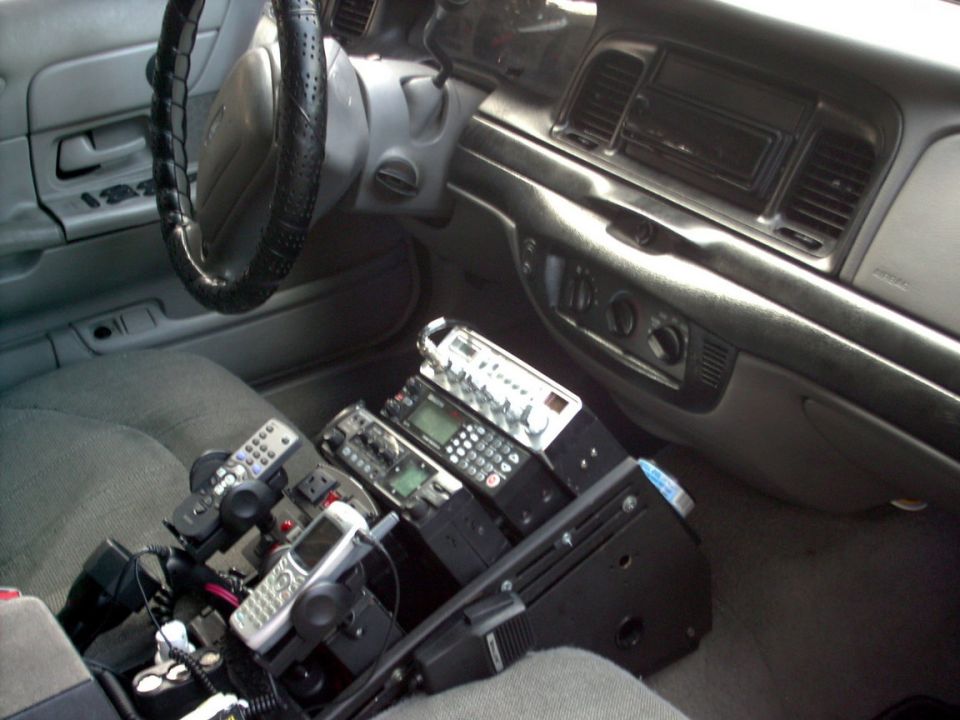 2001 Ford Crown Victoria interior with multiple police radios and cell phones mounted on console