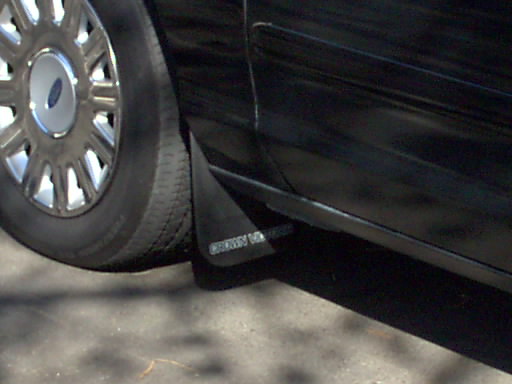 Black mud flap with 'CROWN VICTORIA' text on a 2001 Ford Crown Victoria