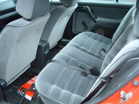 1994 Volkswagen Jetta - The rear interior of a car, showing the seats, door panel, and floor with some scattered paperwork.