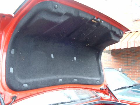 1994 Volkswagen Jetta - The interior of a car's trunk is shown, with a second vehicle partially visible in the background.