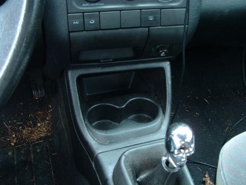 1994 Volkswagen Jetta - The interior of a car features a skull-shaped shift knob and dual cup holders.