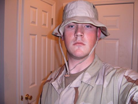 1988 Ford Bronco - A person in a camouflage uniform and hat poses for a photo indoors.