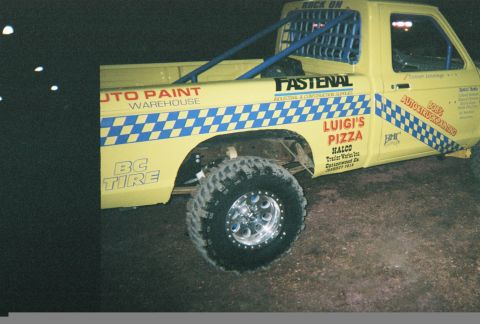 1983 Ford Bronco - This yellow pickup truck features various sponsor decals, including 'Luigi's Pizza' and 'Auto Paint Warehouse', and appears to be modified…