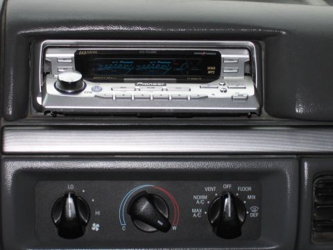 1992 Ford Bronco - Close-up of a car's dashboard showing the stereo system and climate controls.