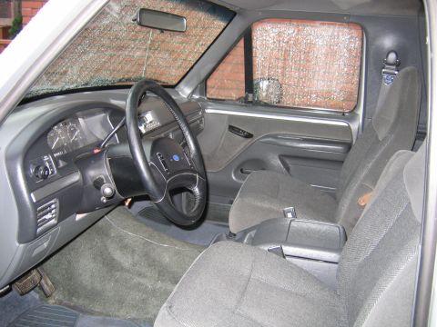 1992 Ford Bronco - The interior of a 1992 Ford Bronco shows gray cloth seats and a dashboard with a steering wheel.