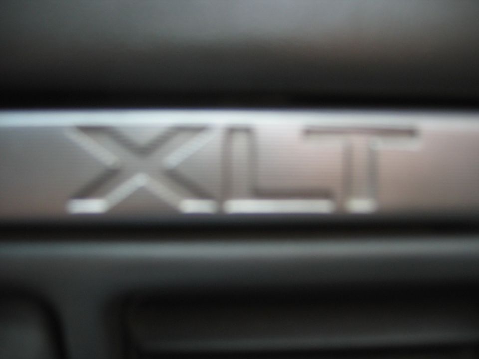 Close-up of an XLT badge on a dark surface