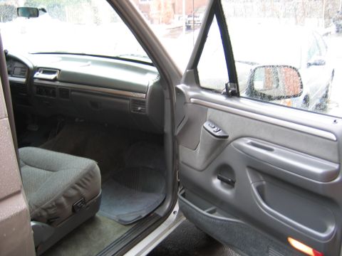 1992 Ford Bronco - The interior of a truck is shown, including the dashboard, passenger seat, and door panel.